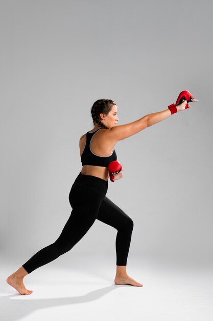Каратэ двигает женщину, пробивающую боксерские перчатки