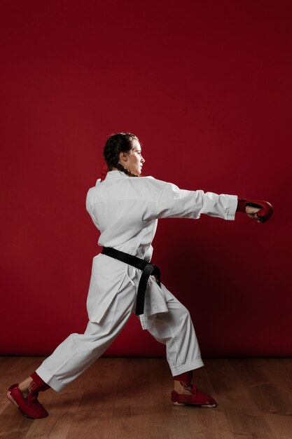 Karate woman in action isolated in red background