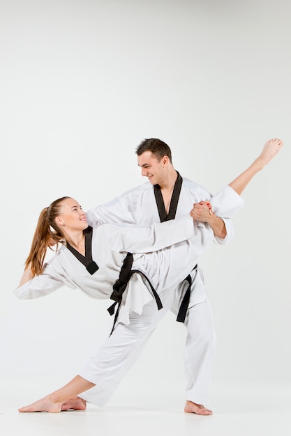 Free photo the karate woman and man with black belts