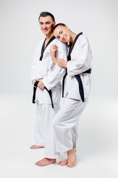 Free photo the karate woman and man with black belts