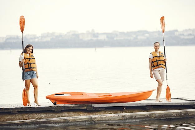 Free photo kayaking. a women in a kayak. girls prepare to padding on a lake.