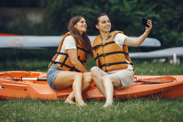 Free photo kayaking. a women in a kayak. girls prepare to padding on a lake.