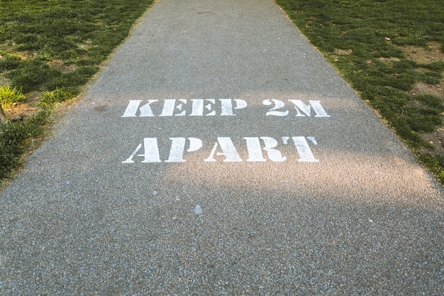 Keep 2m apart written on the ground- the concept of social distancing