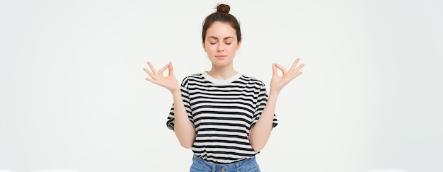 Keep calm and meditate young woman relaxing standing in asana zen pose holding hands sideways and