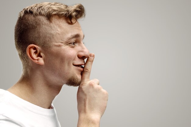 Keep silence. Handsome young man in white shirt