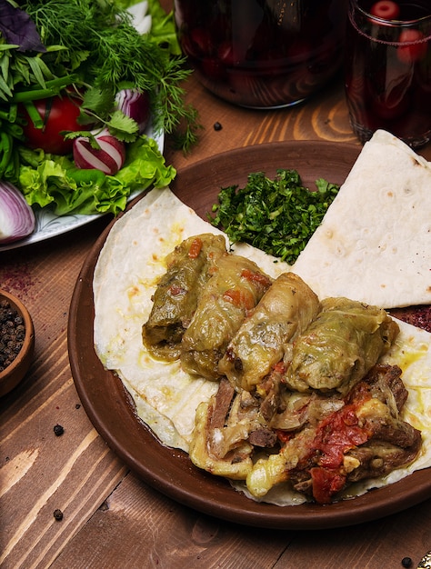 Kelem dolmasi, cabbage leaves stuffed with meat and rice, with beef stew with vegetables in lavash.