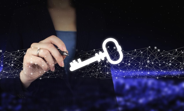 Key keyword icon business internet technology concept. hand holding digital graphic pen and drawing digital hologram key sign on city dark blurred background. cyber security network.