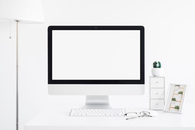 Keyboard near monitor and eyeglasses on table