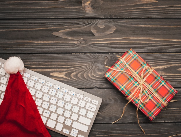 Free photo keyboard with christmas hat on wooden background