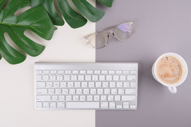 Free photo keyboard with coffee cup and glasses