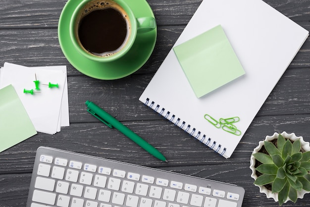 Keyboard with succulent plant and sticky notes on wooden desk