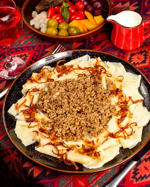 Khinkal with fried onions and meat served with pickles