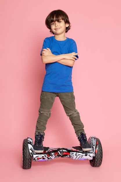 Free photo kid in blue t-shirt riding segway on pink