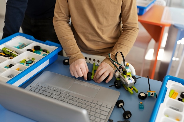 Foto gratuita ragazzo che costruisce un robot usando parti elettroniche