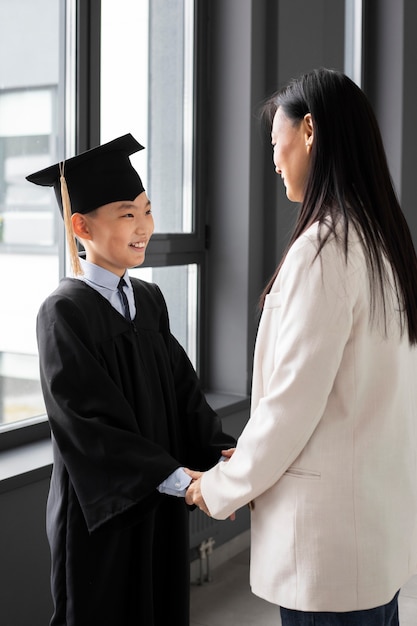 Kid Celebrating Kindergarten Graduation With Parent