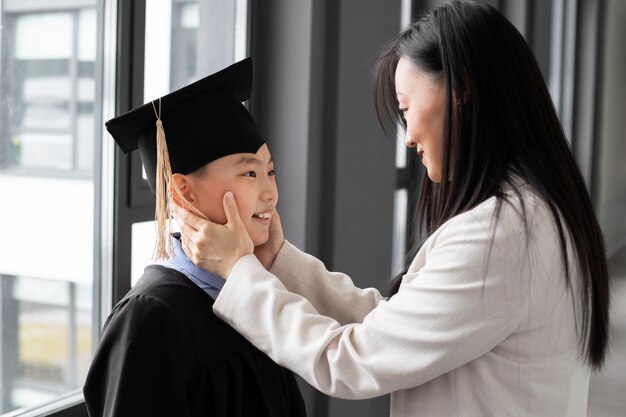 Kid celebrating kindergarten graduation with parent