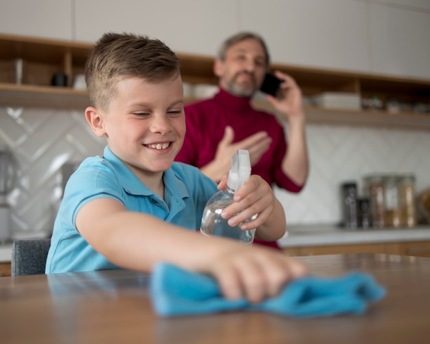 Kid cleaning table medium shot