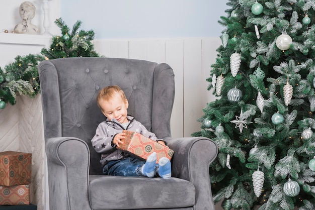 Free photo kid on couch with present