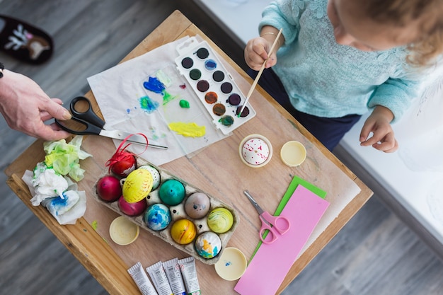 Foto gratuita kid decorare le uova per pasqua