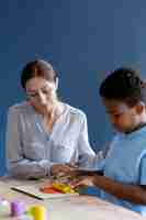 Free photo kid doing a occupational therapy session with a psychologist