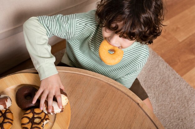 家でドーナツを食べる子供