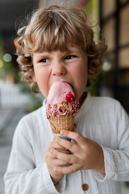 Bambino che mangia il cono gelato
