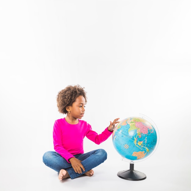 Kid exploring globe in studio 