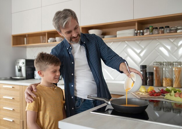 kid and father cooking in kitchen