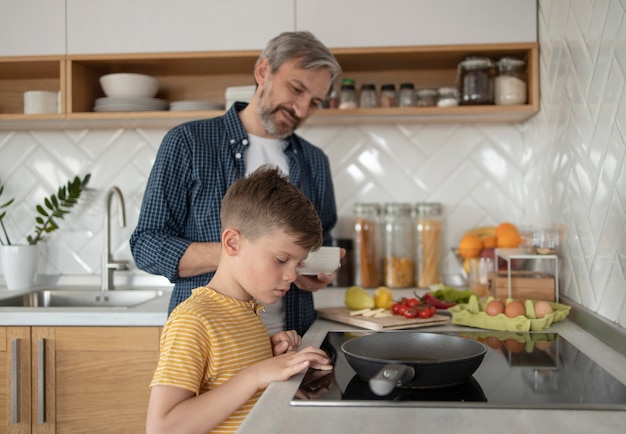 Kid and father cooking medium shot