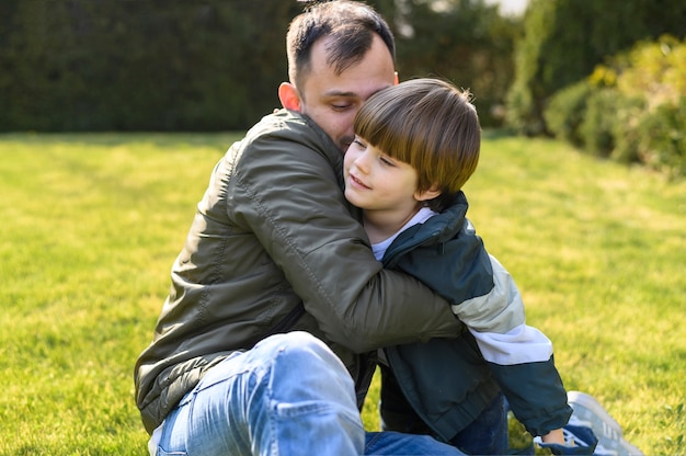 Bambino e padre che abbracciano sull'erba