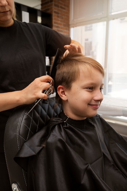 Kid getting haircut at salon side view