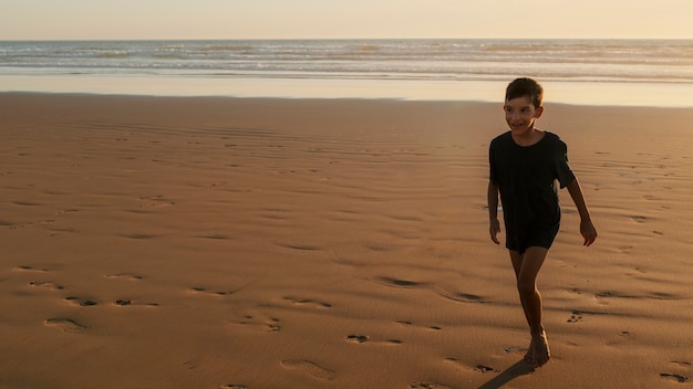 무료 사진 해변에서 즐거운 시간을 보내는 아이