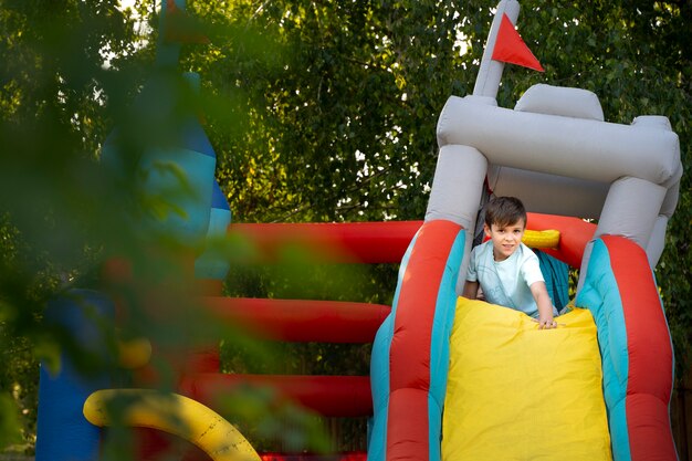 Kid having fun in bounce house full shot