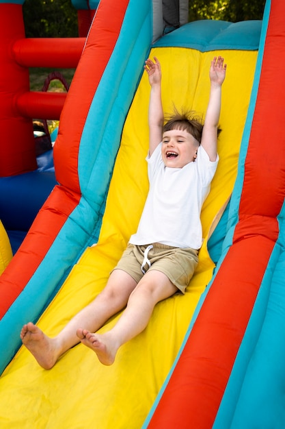 Kid having fun in bounce house full shot