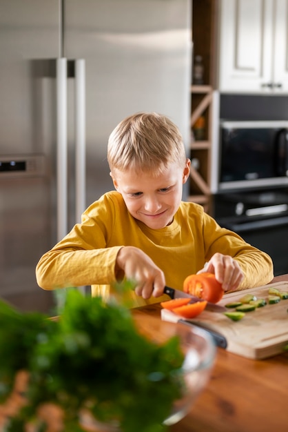 Foto gratuita bambino che si diverte a cucinare in cucina a casa