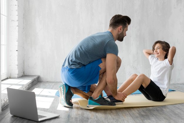 Kid and his father doing sport at home