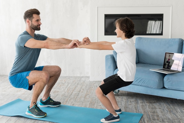 Free photo kid and his father doing sport at home