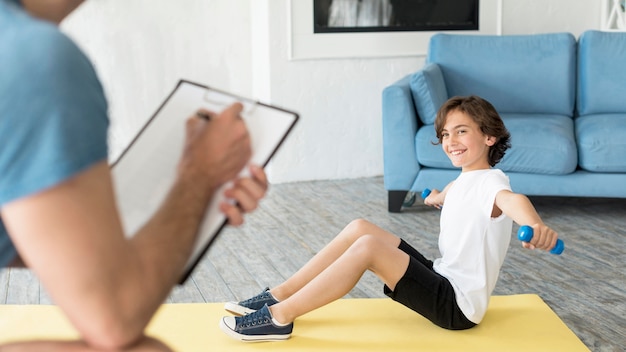 Free photo kid and his father doing sport at home