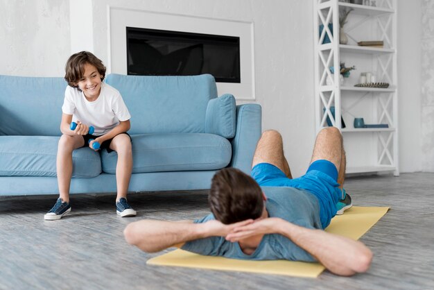 Kid and his father doing sport at home