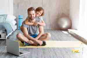 Free photo kid and his father doing sport at home