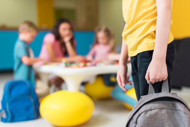 Free photo kid holding a backpack with copy space