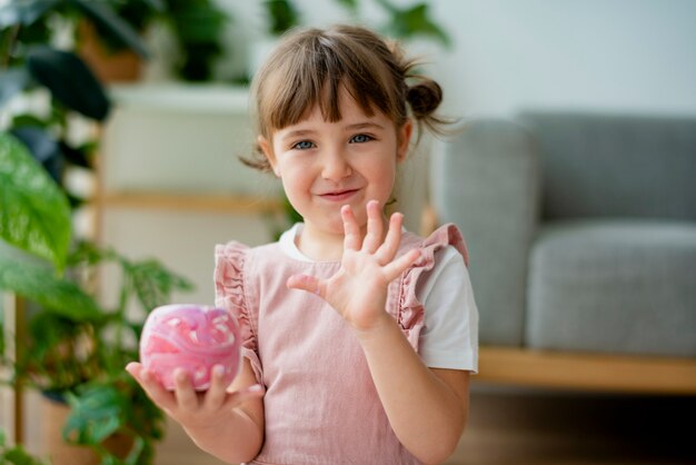 Ребенок держит раскрашенный горшок для цветов своими руками