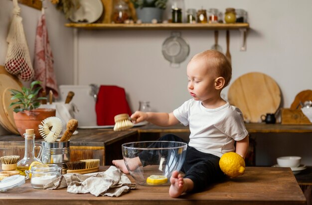 Ребенок держит лимон и кисть полный выстрел