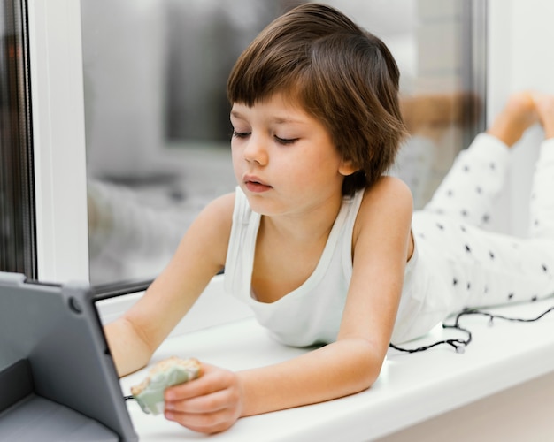 Kid in casa guardando tablet