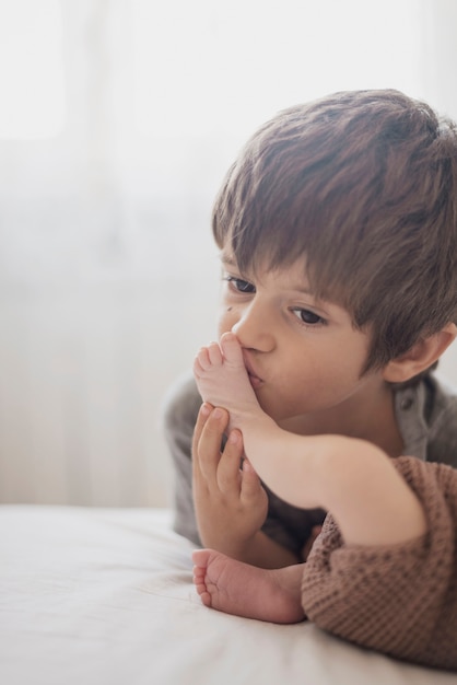 子供は彼の弟の足にキス