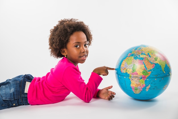 Kid laying and with globe in studio 