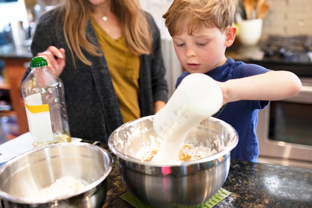 Free photo kid learning how to bake with mom education photo