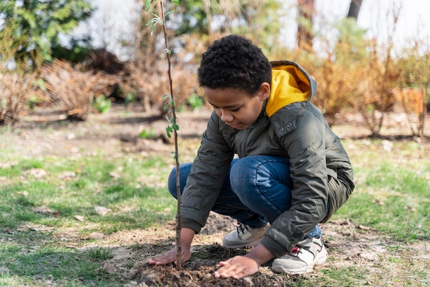 Bambino che impara a piantare un albero