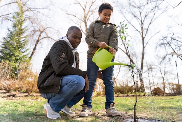 Free photo kid learning how to plant a tree