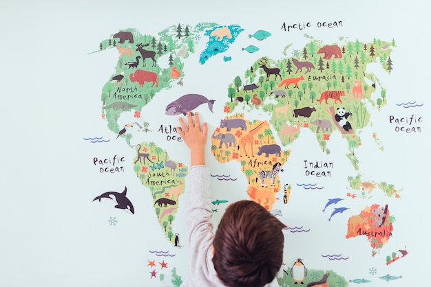 Foto gratuita bambino guardando la mappa del mondo